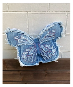 Detail of blue denim butterfly bag showing heavy distressed edges and red stitching