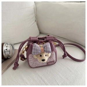Dettaglio della borsa a secchiello viola con orsetto di peluche e fiocco a scacchi
