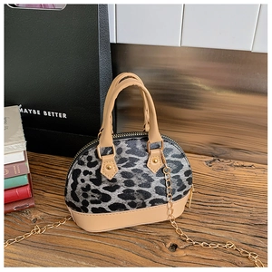 Detail der Mini-Muschel-Tasche mit Leopardenmuster, beigem Leder und goldener Kette