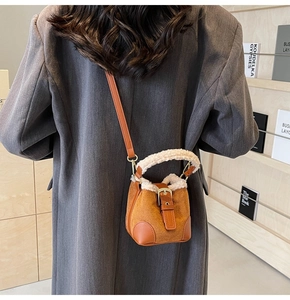 Detailansicht der braunen Mini-Eimertasche aus Wildleder mit weichem Fleece-Griff und Gurt