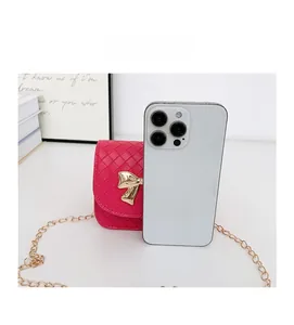 Mini sac bandoulière tissé magenta avec nœud doré comparé à un smartphone pour la taille