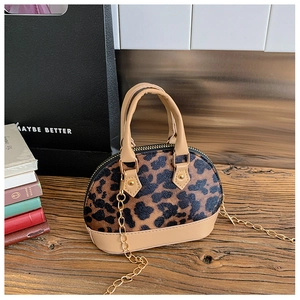 Detailansicht der Mini-Muscheltasche mit Leopardenmuster und Kette auf Holztisch