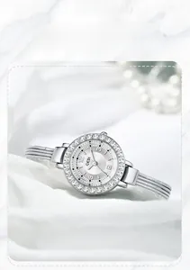 Detail showing GEDI silver quartz watch with diamond bezel on elegant white silk