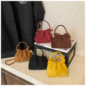 Dettaglio di cinque mini borse in pelle scamosciata con coulisse e manici rotondi