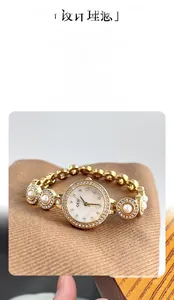Détail de la montre bracelet dorée ornée de perles et de cristaux sur le bracelet