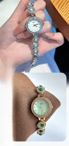 Détail d'une montre de luxe pour femme avec bracelet perles et incrustation émeraude