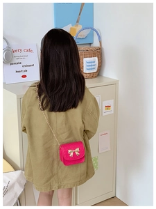 Détail du petit sac bandoulière matelassé rose avec nœud doré et chaîne pour enfants