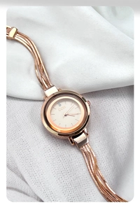 Detail of rose gold quartz watch featuring a multi-strand snake chain and crystal dial