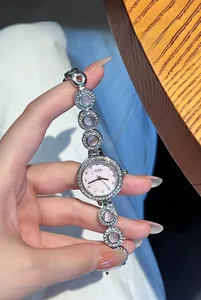 Détail d'une montre bracelet en argent avec pierres roses et cadran en nacre douce