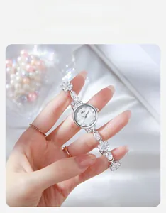 Détail d'une montre bracelet fleur en argent sertie de zircons avec décor de perles