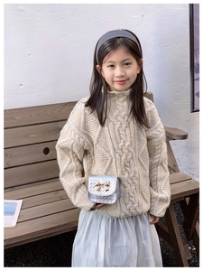 Détail du mini sac argenté matelassé pour enfants avec nœud doré et bandoulière chaîne