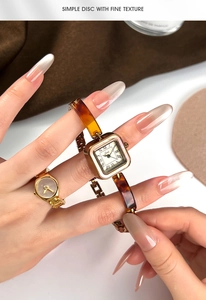 Detail of vintage square watch and ring set with amber texture and gold metal accents