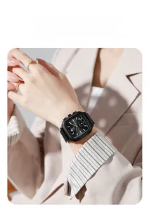 Detail of a square black business watch with sub-dials and buttons on a male wrist