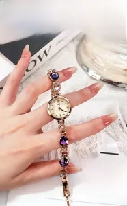 Dettaglio orologio donna oro rosa con pietre a cuore viola e quadrante in madreperla
