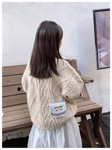 Détail du sac à bandoulière enfant matelassé argenté avec nœud doré et chaîne