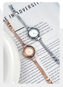 Detail view of gold and silver minimalist watches on a book background with metal straps