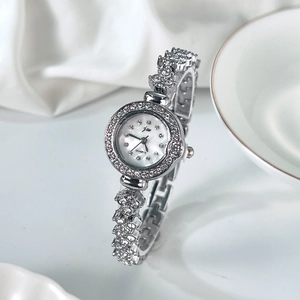 Élégante montre bracelet argentée pour femme avec strass et cadran en nacre blanche