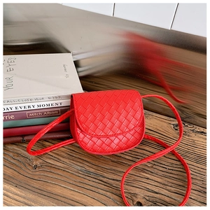 Detail of red quilted crossbody bag with semicircular flap and thin leather strap