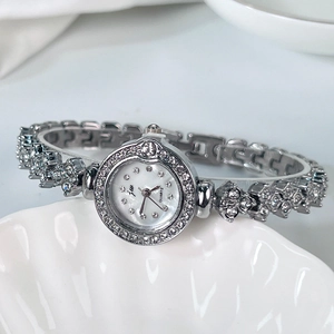 Gros plan d'une montre bracelet à quartz argentée avec strass et cadran en nacre