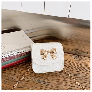 Détail d'un mini sac bandoulière blanc tissé avec boucle nœud doré et chaîne fine