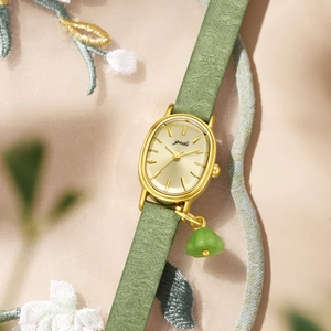 Elegant gold oval watch for women with green bead pendant and champagne dial on floral embroidery