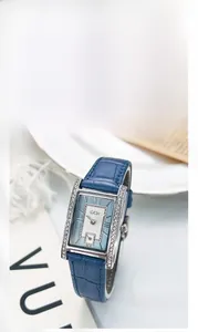 Macro shot of rectangular silver watch with crystal bezel and blue leather strap