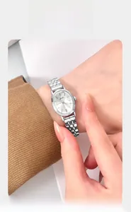 Close-up of minimalist silver oval quartz watch with elegant metal link strap on wrist