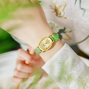Gedi gold oval watch for women with green textured strap and heart pendant detail