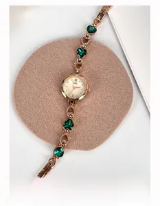 Dettaglio dell'orologio GEDI in oro rosa con cuori di smeraldo e cristalli scintillanti