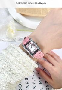 Detail of pink croc leather strap and square diamond bezel watch on a woman's wrist