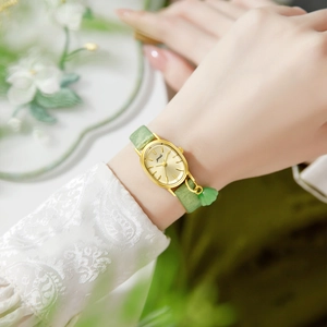 French vintage style gold oval watch for women with green strap and leaf charm pendant