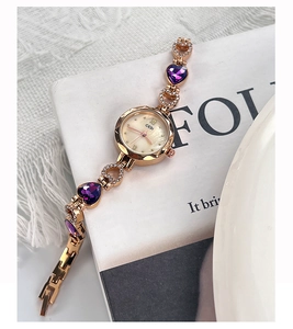 Dettaglio orologio a bracciale oro rosa con cristallo a cuore viola e quadrante