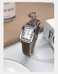 Detailed view of silver square quartz watch with white sunburst dial and brown leather strap