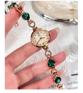 Dettaglio orologio a bracciale in oro rosa con cristalli a cuore smeraldo e madreperla