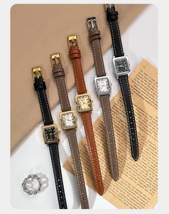 Elegant collection of small square vintage quartz watches with leather straps on a retro desk