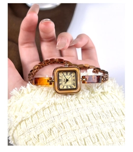 Close-up of vintage square watch with copper metal case and amber resin link chain strap