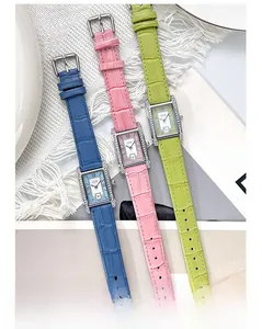 Close-up of three colorful square quartz watches with rhinestone bezels and leather straps
