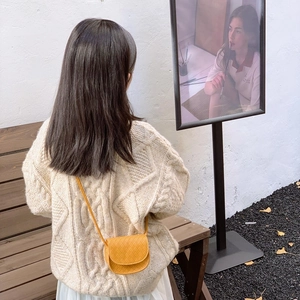 Quilted yellow crossbody bag for kids styled with a cream sweater and white skirt