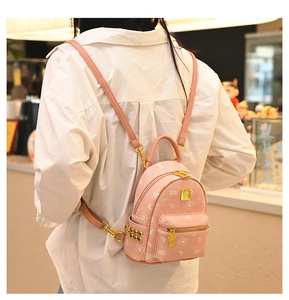 Pink mini backpack detail featuring cute white bear patterns and gold studded accents