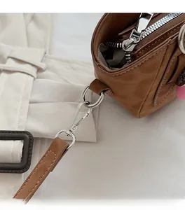 Detailed macro view of high-quality silver metal hardware and brown leather shoulder bag