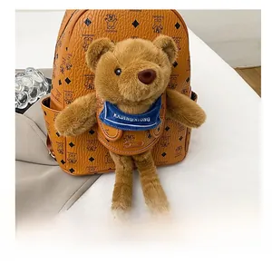 Dettaglio dello zaino in pelle marrone con orsetto di peluche e stampa logo moda