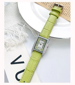 Macro shot of GEDI silver rectangular watch with side diamonds and green leather strap