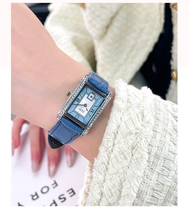 Detail of square quartz watch with light blue dial, silver diamond bezel and leather strap