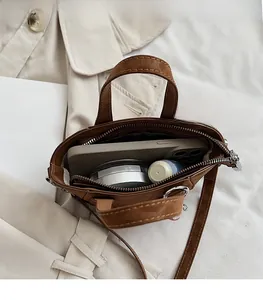 Overhead view showing large interior capacity of brown vintage crossbody bag for daily items