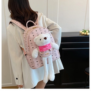 Dettaglio dello zaino rosa in similpelle con ciondolo a forma di orsetto di peluche