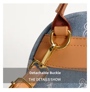 Detail of detachable golden metal clasp on blue denim backpack with brown leather trim