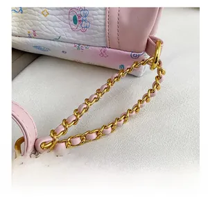 Detail show of premium gold-toned chain strap with woven pink leather on a white bag