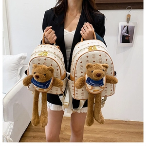 Dettaglio del set zaino crema con orsetti di peluche 3D e motivi geometrici stampati