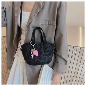Detail of black leopard print mini bag with pink heart and silver key charms