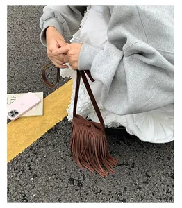 Détail du mini sac bandoulière en daim marron avec de longues franges au style bohème